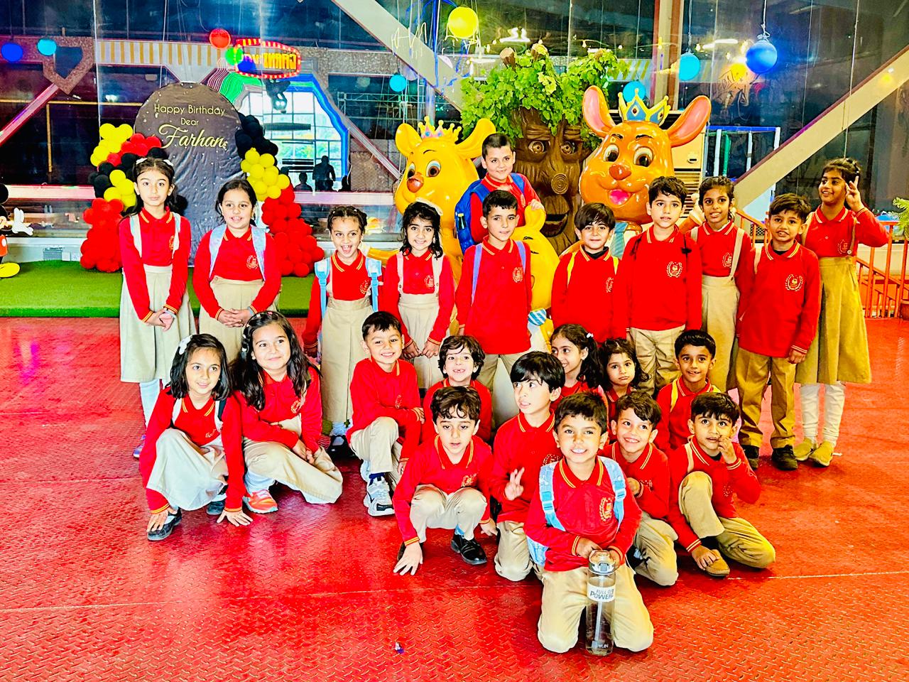 Children celebrating a school birthday event with character mascots